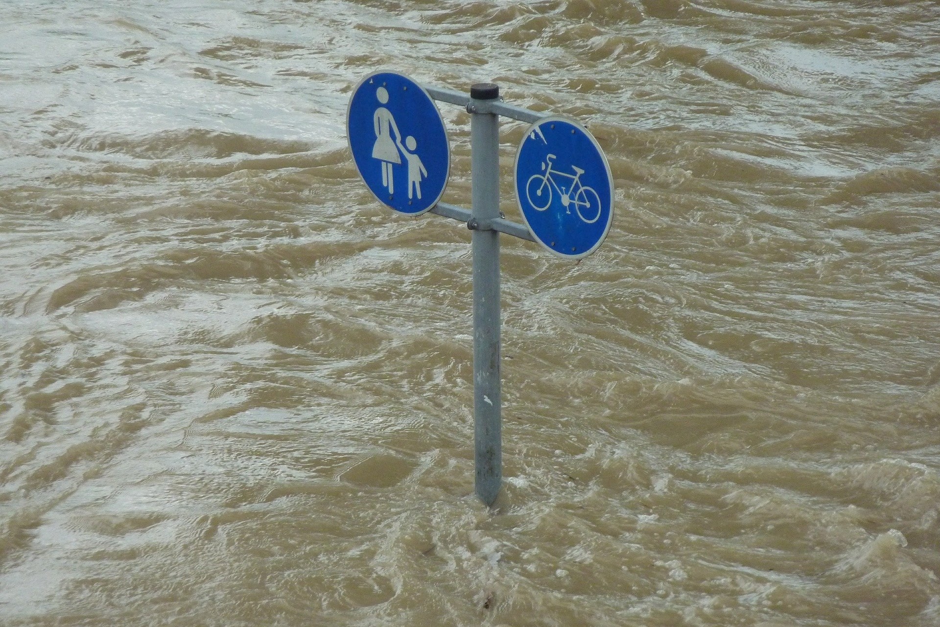 Ein Straßenschild das in Hochwasser steht